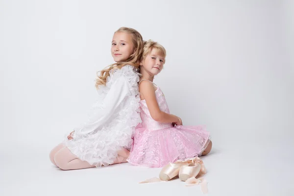 Сестры-блондинки позируют с пуантами в студии — стоковое фото