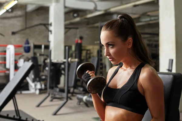 Chica sexy posando mientras hace ejercicio en el gimnasio — Foto de Stock