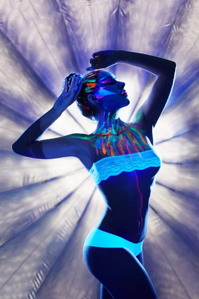 Unreal girl with luminous body art in spotlight — Stock Photo, Image