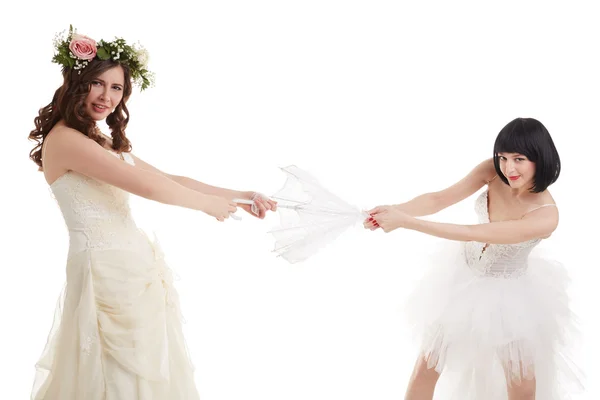 Красивые соперники в свадебных платьях разделяют зонтик — стоковое фото