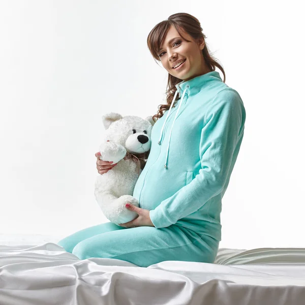 Gelukkig aanstaande moeder in casual kleding met speelgoed — Stockfoto