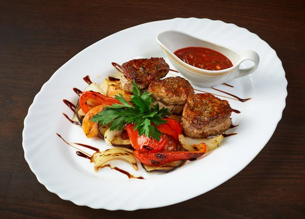 Meat cutlets with roasted vegetables and sauce — Stock Photo, Image