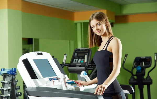 Menina bonito exercício no simulador no ginásio — Fotografia de Stock