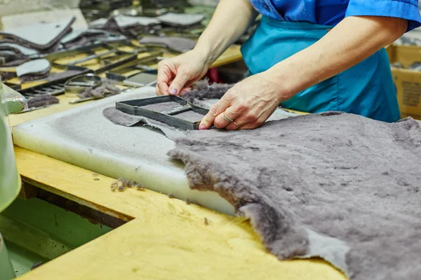Production of fur insoles. Worker uses template — Stock Photo, Image