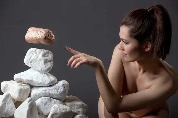 Chica desnuda mueve piedra sin tocarlo —  Fotos de Stock