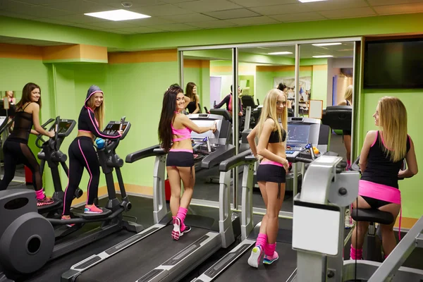 Alegres chicas deportivas haciendo ejercicio en el gimnasio —  Fotos de Stock