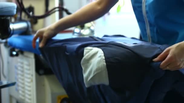 View of laundry worker ironing jacket — Stock Video