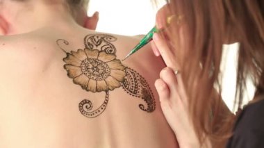 Mehndi sanatı. Kızlar arkasında usta çizer