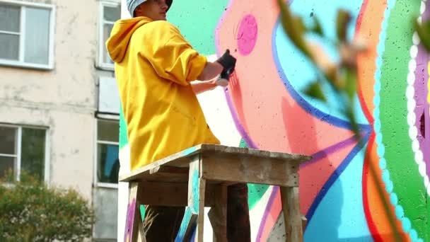 Mann zeichnet mit Farbe aus Spray an Wand — Stockvideo