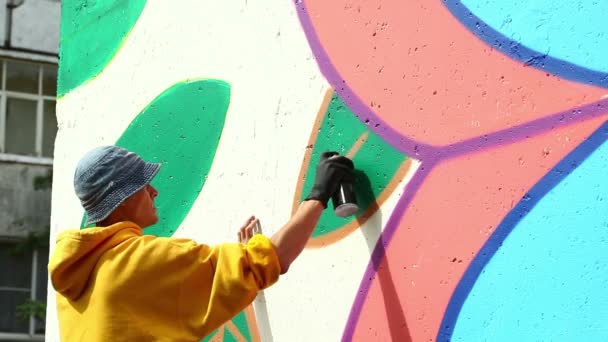 Guy drawing with spray on wall in city park — Stock Video