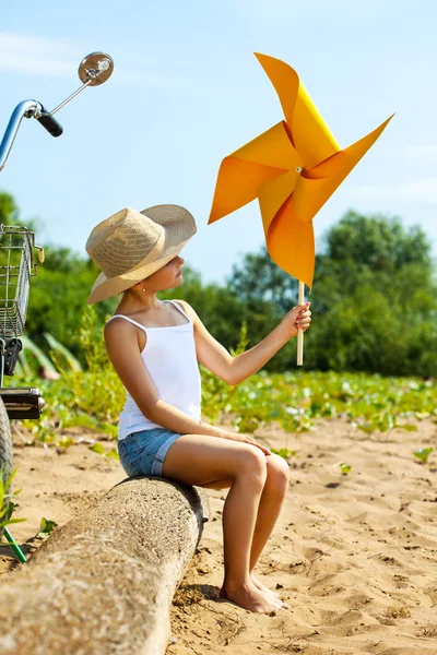 Adorable fille jouer avec moulin à vent en papier — Photo