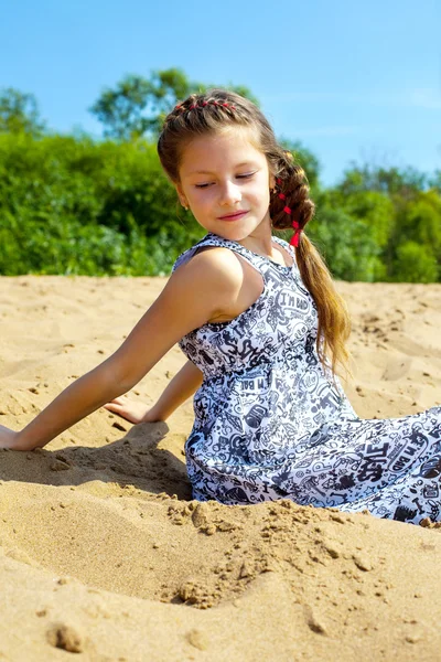 Portrait de jolie fille assise sur le sable — Photo