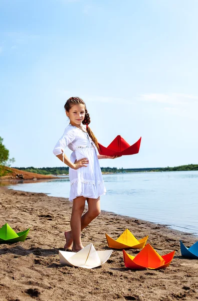 可爱的小女孩，用彩色的纸小船构成 — 图库照片