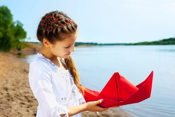 可爱的女孩，用红纸小船的形象 — 图库照片