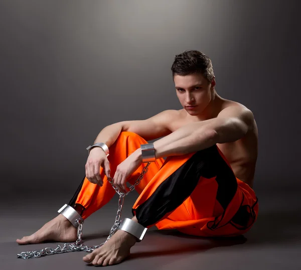 Bonito modelo masculino posando como prisioneiro em estúdio — Fotografia de Stock