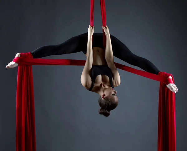 Sexy female acrobat performs hanging upside down — Stock Photo, Image