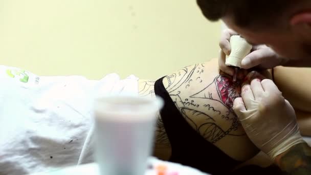 Maître de tatouage professionnel dessine sur la hanche des femmes — Video