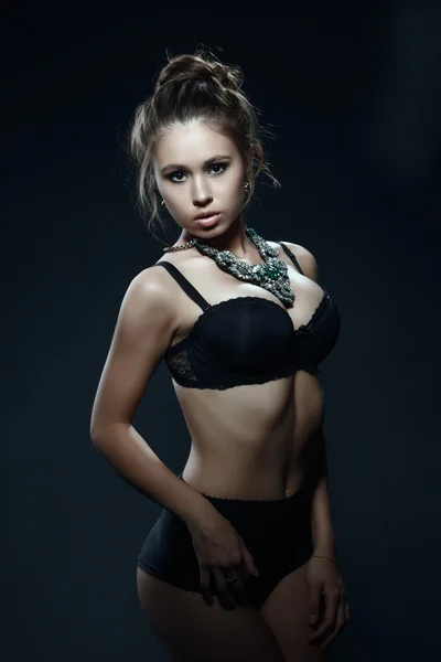 Bella giovane donna in posa in lingerie e collana — Foto Stock