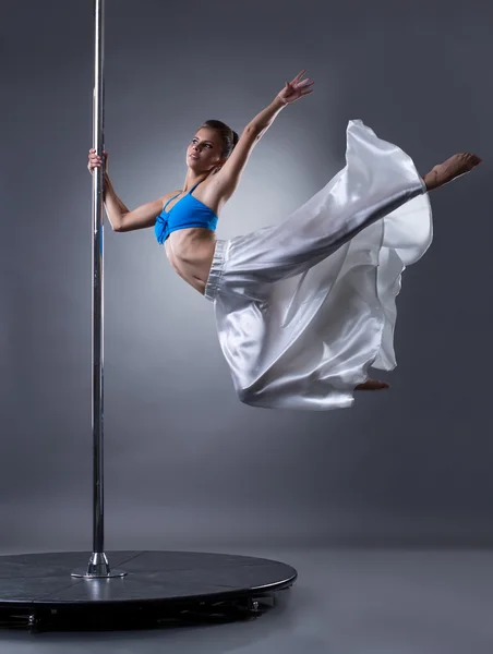 Hübsche Tänzerin dreht sich um Pylon — Stockfoto