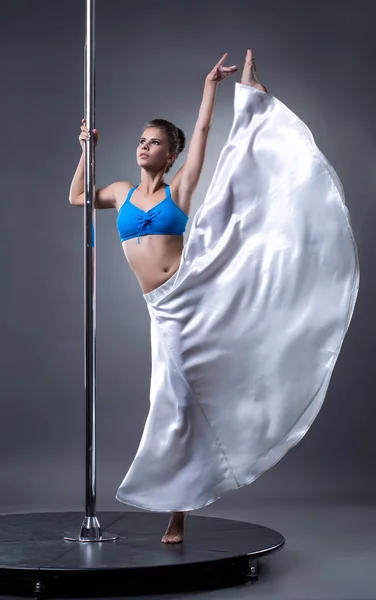 Bailarina elegante posando en el pilón, sobre fondo gris — Foto de Stock