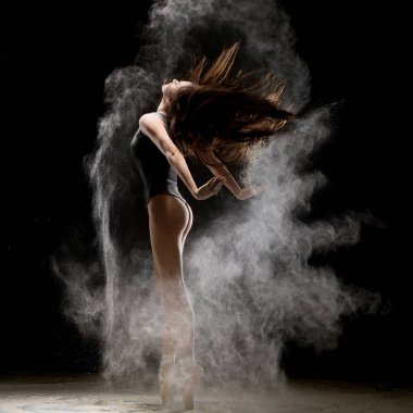 Siyah elbise siyah zemin karşı toz yığını uçan dans güzel ifade kadın görünümünü