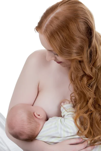 Schöne rothaarige Mutter, die ihr Kind stillt — Stockfoto