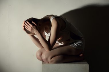 Mental illness. Shot of thin girl holding her head