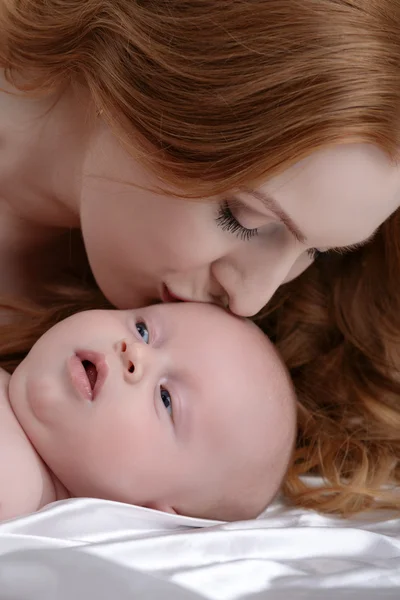 Retrato de mãe beija seu adorável filho — Fotografia de Stock