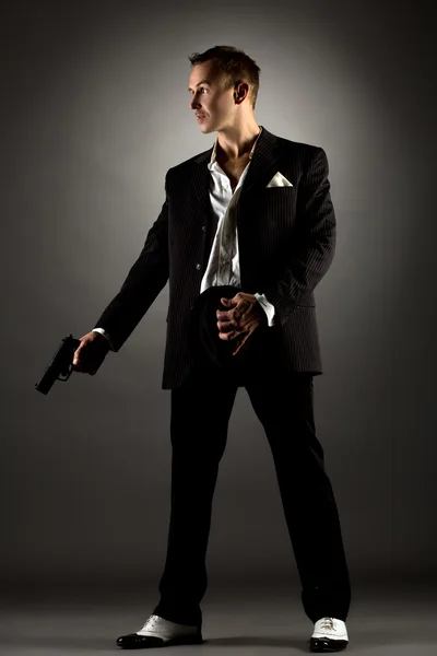Pohledný muž, oblečený jako gangster pistolí — Stock fotografie