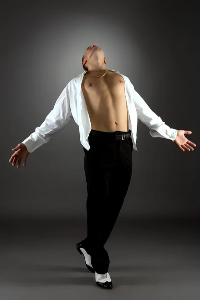 Hombre artístico bailando en estudio, sobre fondo gris — Foto de Stock