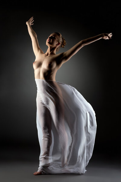 Graceful modern dancer posing naked in studio