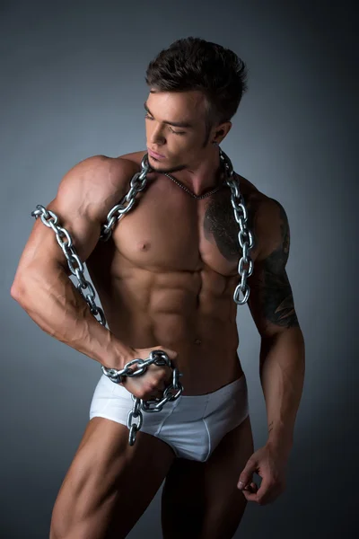 Quente muscular cara envolto seu bíceps com cadeia — Fotografia de Stock