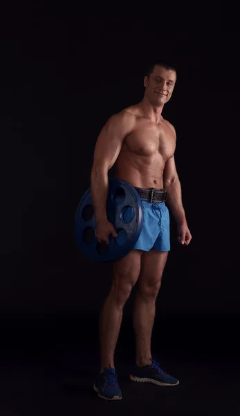 Beau bodybuilder posant avec disque de haltère — Photo