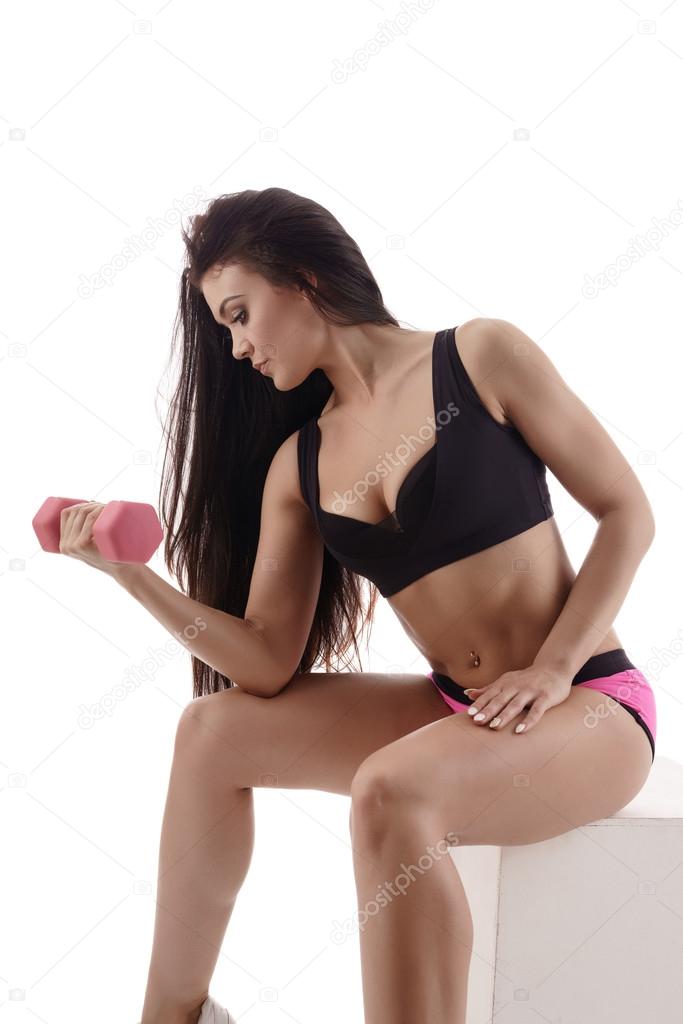 Sexy female athlete exercising her biceps