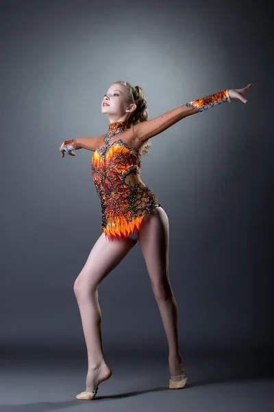 Young artistic gymnast performs in studio — Stock Photo, Image