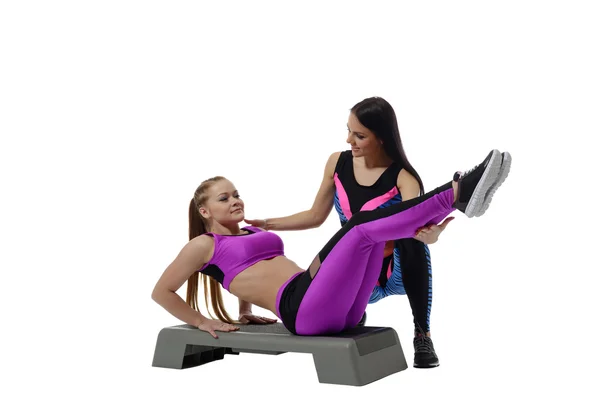 Fitness coach helping girl do exercise on stepper — Stock Photo, Image