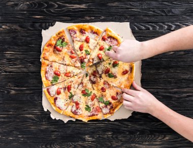 Pizza üstten görünüm kesme eller