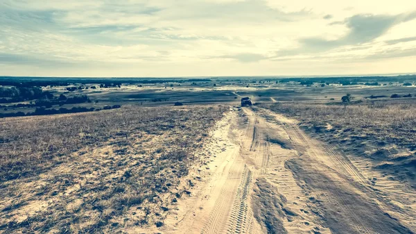 Estrada rolou em um campo arenoso — Fotografia de Stock