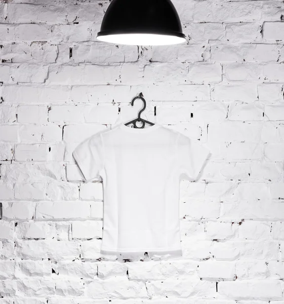 Біла футболка на білій стіні — стокове фото
