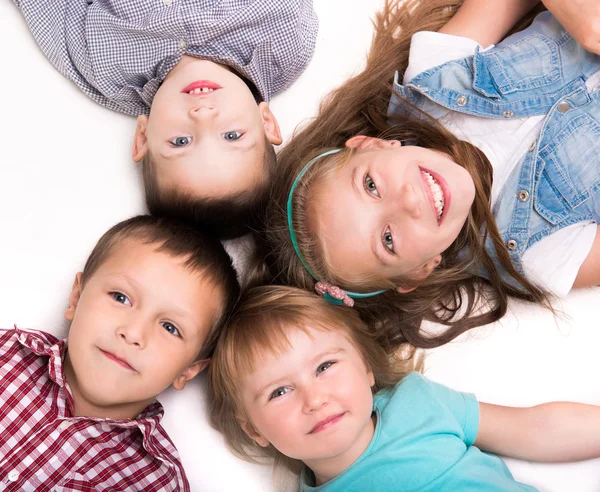 Children lying head to head on the floor Stock Photo