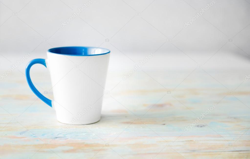 white cup with blue handle and inner surface