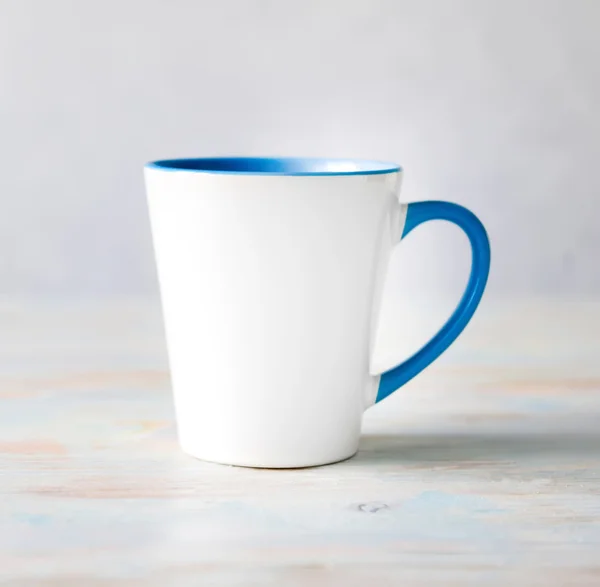 Taza blanca con mango azul y superficie interior — Foto de Stock