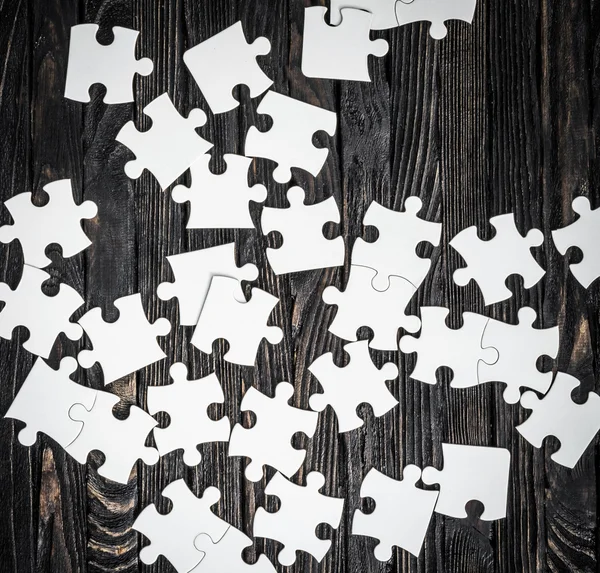 White puzzle pieces on dark background — Stock Photo, Image