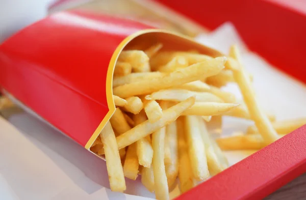 Batatas fritas em embalagem de cartão vermelho — Fotografia de Stock