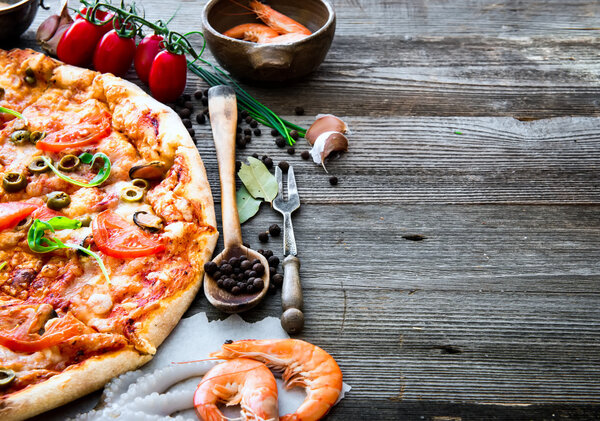 Delicious pizza with seafood on wooden table
