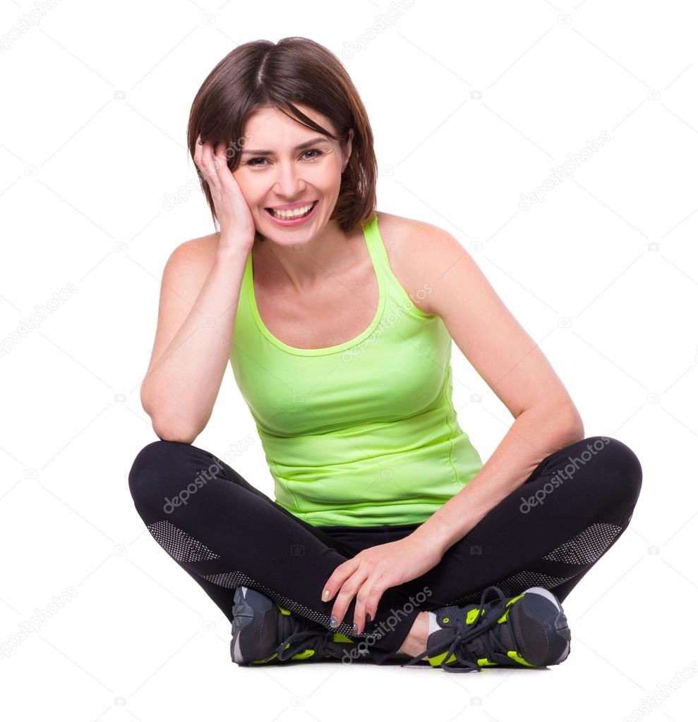 sport girl sitting on the floor with her legs crossed and resting