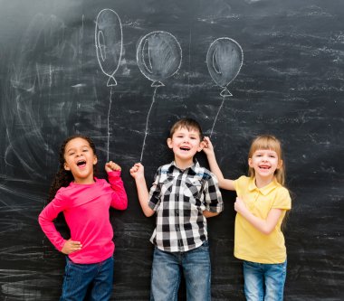 hayali balonların tahtaya çizilen üç neşeli çocuklar tutmak