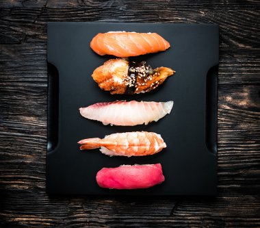Japon suşi sashimi siyah tepsi üzerinde bir dizi