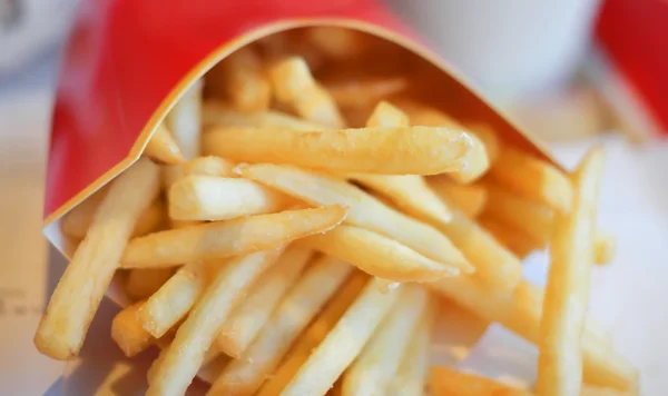 Batatas fritas em embalagem de cartão vermelho — Fotografia de Stock