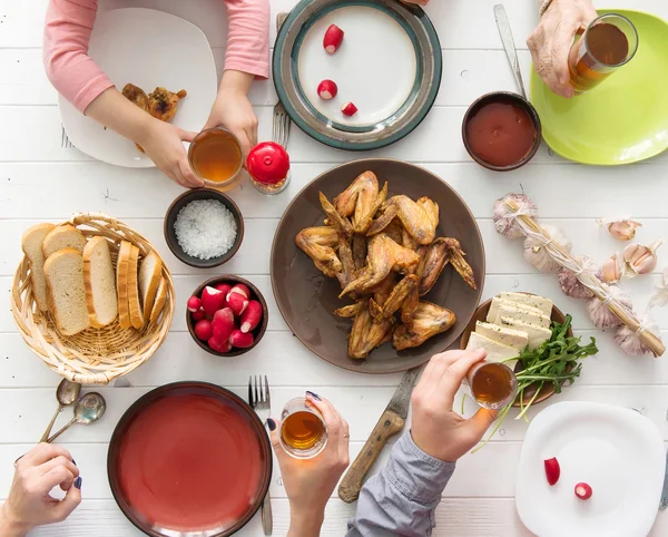 Family dinner with roasted chicken wings — Stock Photo, Image